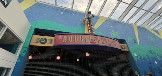 The entrance to the "Double Feature" store at a Disney resort, featuring a closed metal gate and a marquee with Donald Duck perched on top.