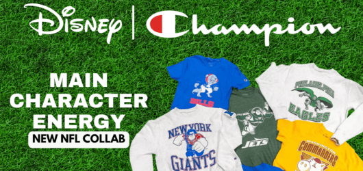 A flat-lay display of the Disney x Champion "Main Character Energy" NFL apparel collection featuring team t-shirts and sweatshirts on a green grass background.