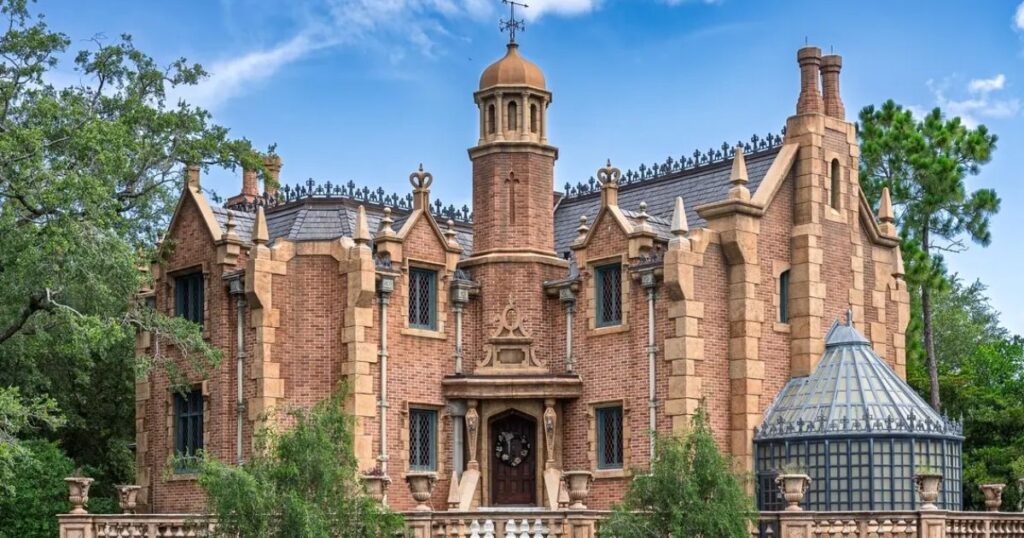Haunted Mansion: Magic Kingdom Ride Guide 2 Exterior view of the Gothic-style Haunted Mansion facade and conservatory at Magic Kingdom in Walt Disney World, Florida.