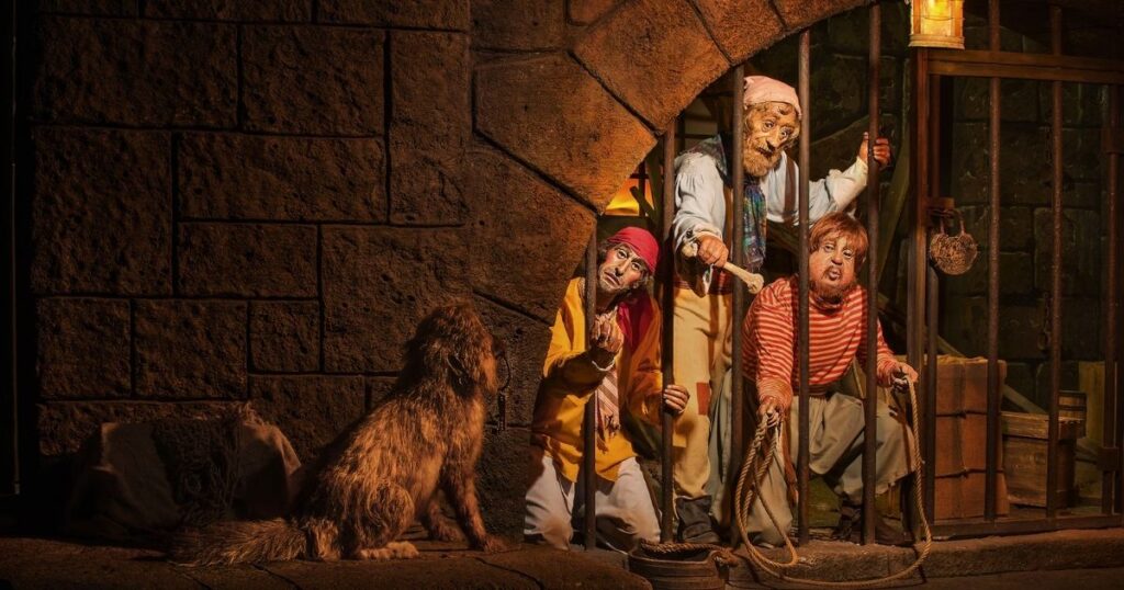 Pirates of the Caribbean: Magic Kingdom Ride Guide 3 Classic Audio-Animatronic jail cell scene from the Pirates of the Caribbean ride featuring pirates trying to entice a dog with keys.