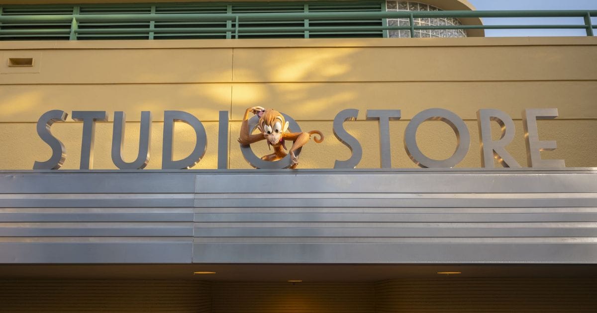 Dimensional figure of Abu from Aladdin perched inside the letter O of the Studio Store building marquee