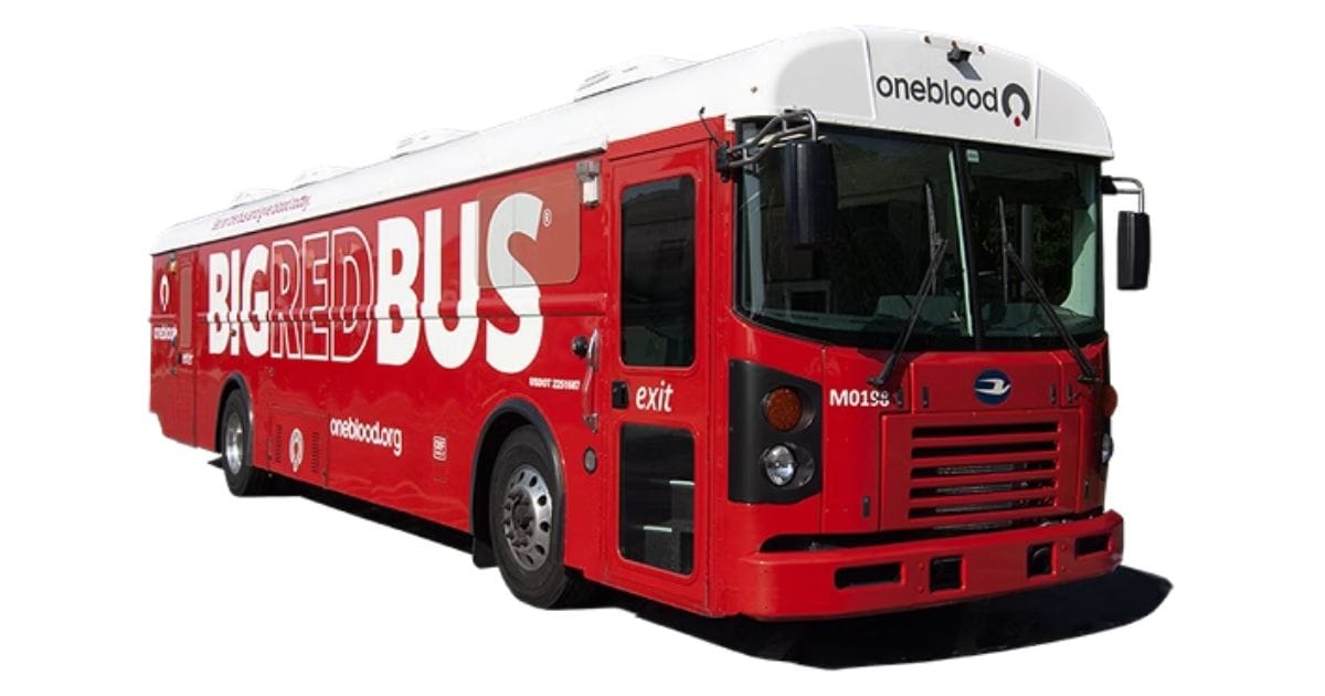 Studio view of the OneBlood Big Red Bus, a mobile blood donation vehicle with bold white lettering on a red chassis