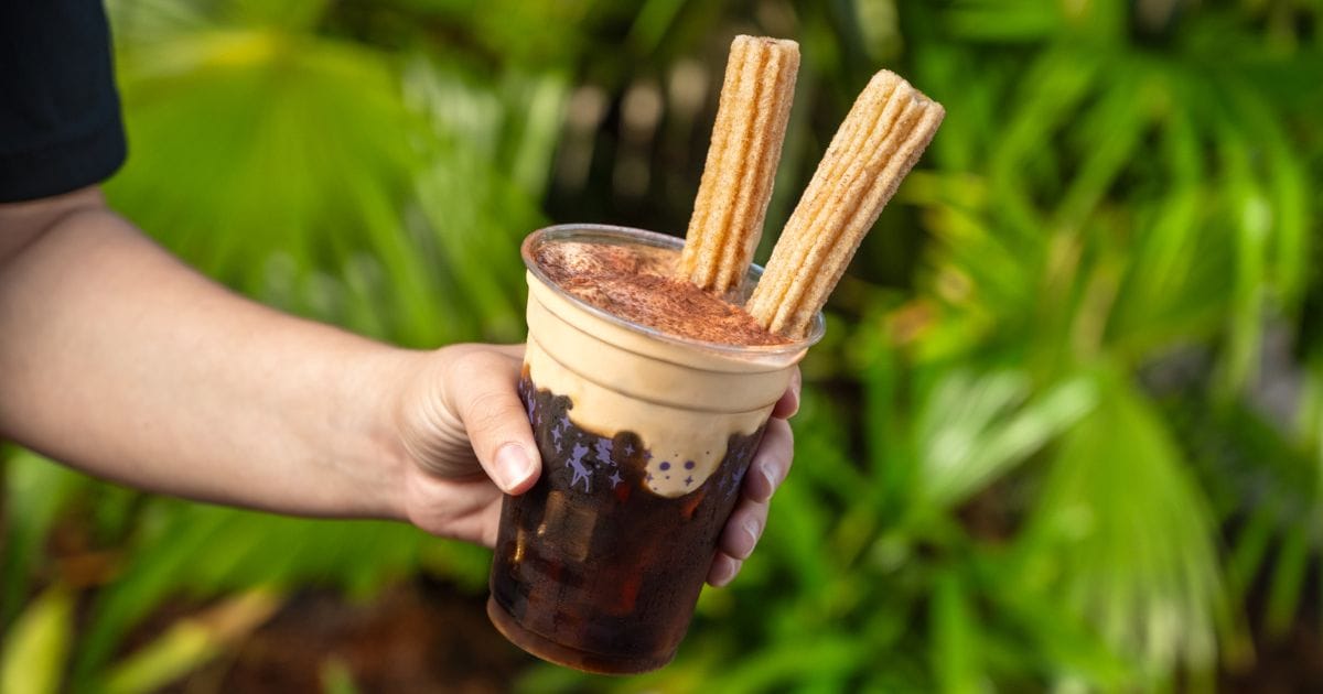 Specialty iced coffee blending rich cold brew with tiramisu-flavored cream foam, cocoa powder, and two dunked mini churros