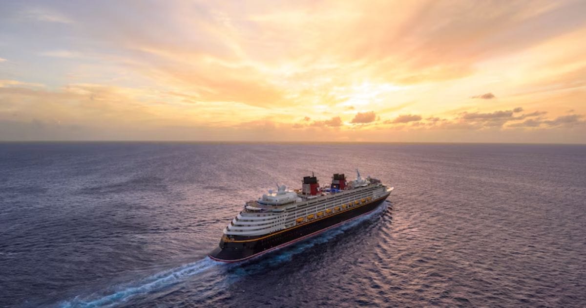 Disney Wish 5-Night Canada & New England Cruise 2027 Booking Guide 4 Aerial view of the Disney Wish navigating open waters during golden hour, highlighting the calm seas and scenic sky during a scheduled day at sea on a Northeast Halloween cruise