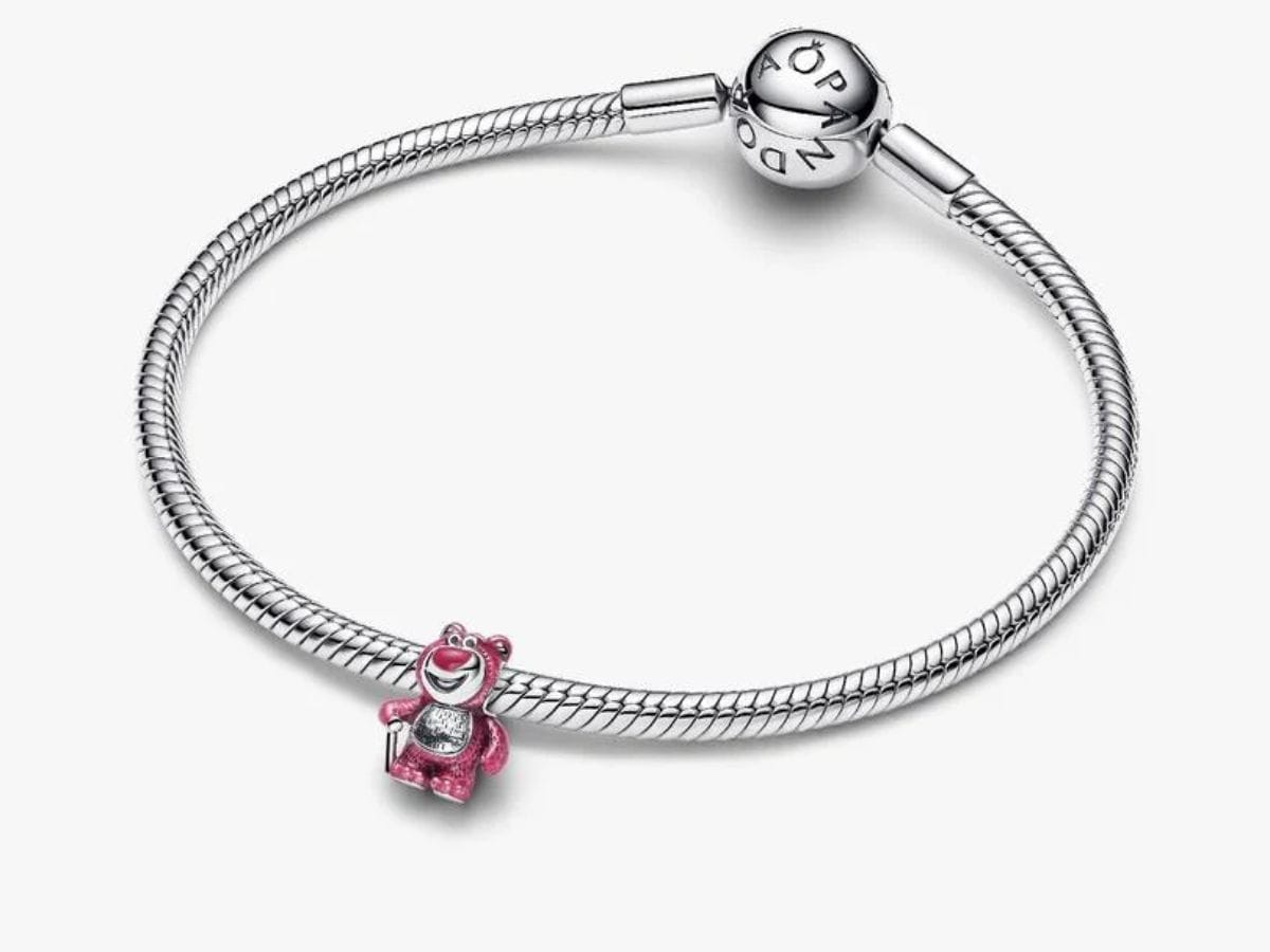 Sterling silver Pandora snake chain bracelet displaying the pink enamel Disney Pixar Villains Lotso Bear Scented Charm.