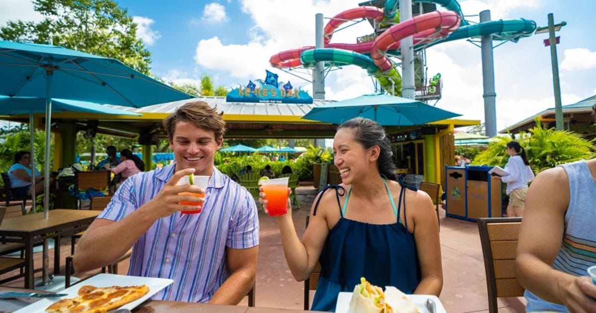 Aquatica Orlando September 2026 Pass Member Perks: Free Tickets & Dining Guide 3 A family eating burgers and fries at an Aquatica Orlando dining location