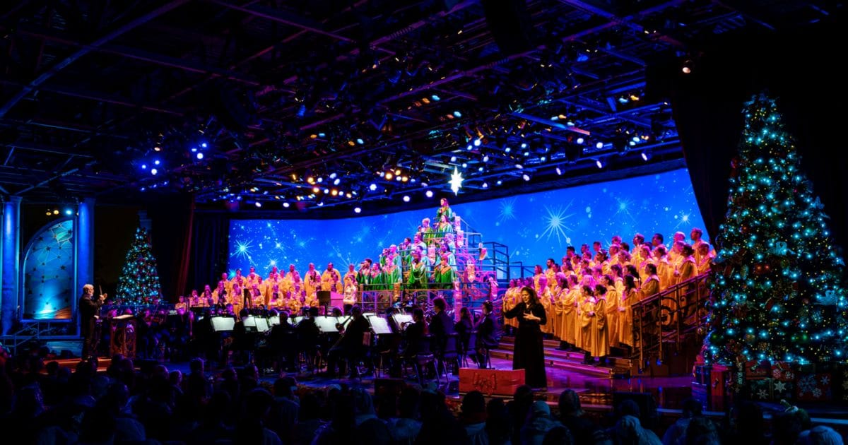 Full stage view of the EPCOT Candlelight Processional during the International Festival of the Holidays with blue starry lighting.