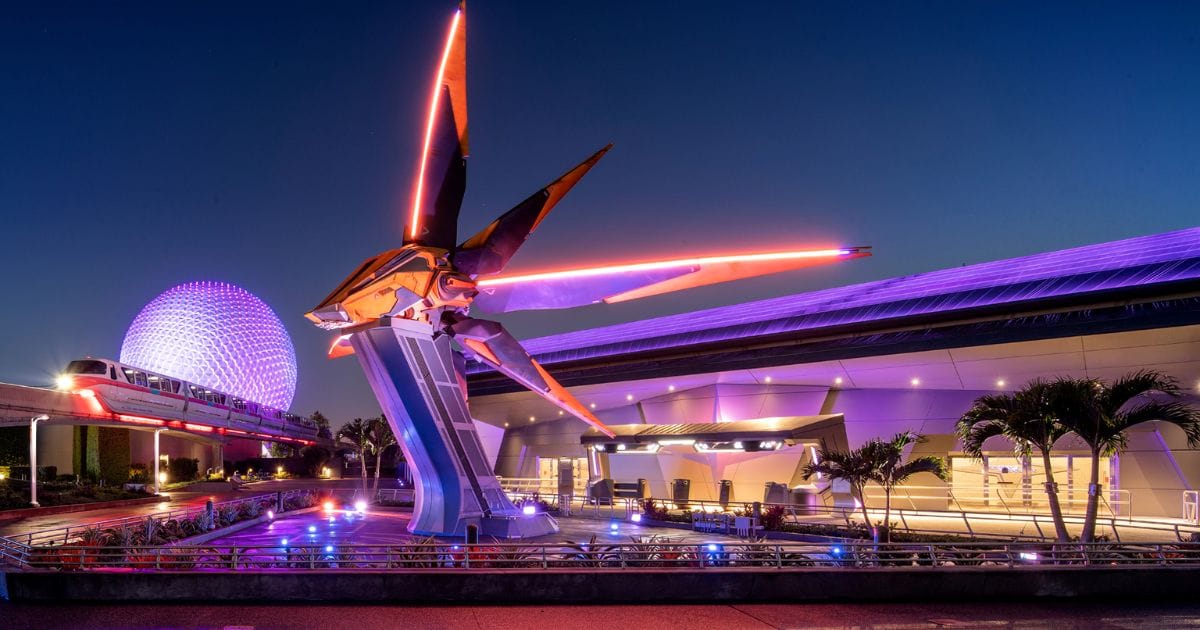 The exterior of the Guardians of the Galaxy: Cosmic Rewind show building at EPCOT lit up after dark.