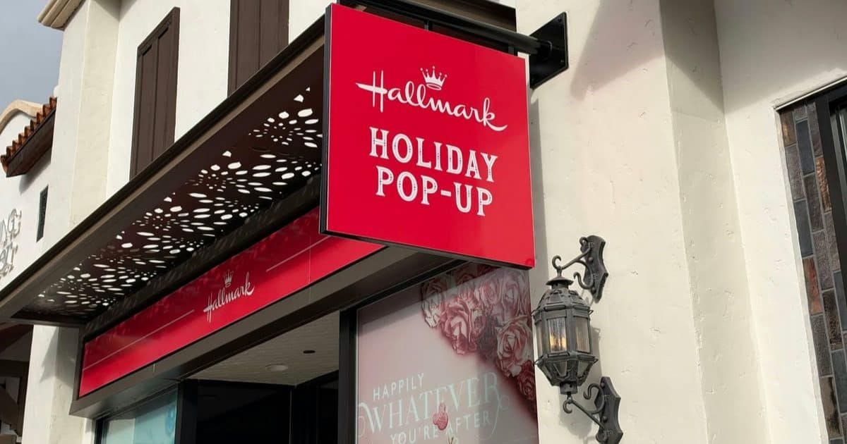 Red hanging exterior sign for the Hallmark Holiday Pop-Up store at Disney Springs