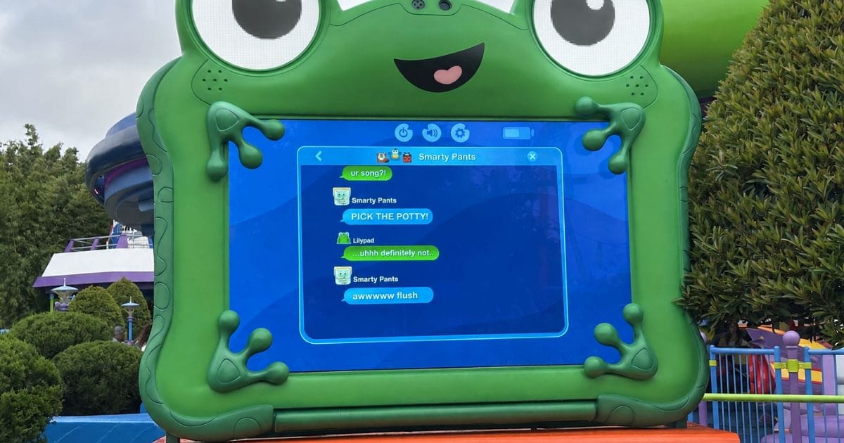 A detailed view of the digital frog display showing a humorous dialogue exchange between characters Smarty Pants and Lilypad regarding playlist song choices in Disney's Hollywood Studios