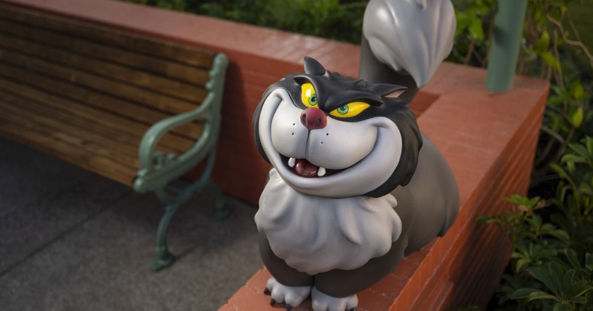 Sculpted dimensional figure of Lucifer the cat from Cinderella grinning atop a brick planter wall