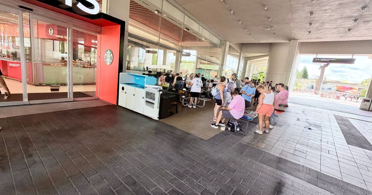 EPCOT Pin Trading Controversy: Breezeway Relocation and Rule Updates 2 Disney pin traders with large binders spread across tables in an EPCOT breezeway