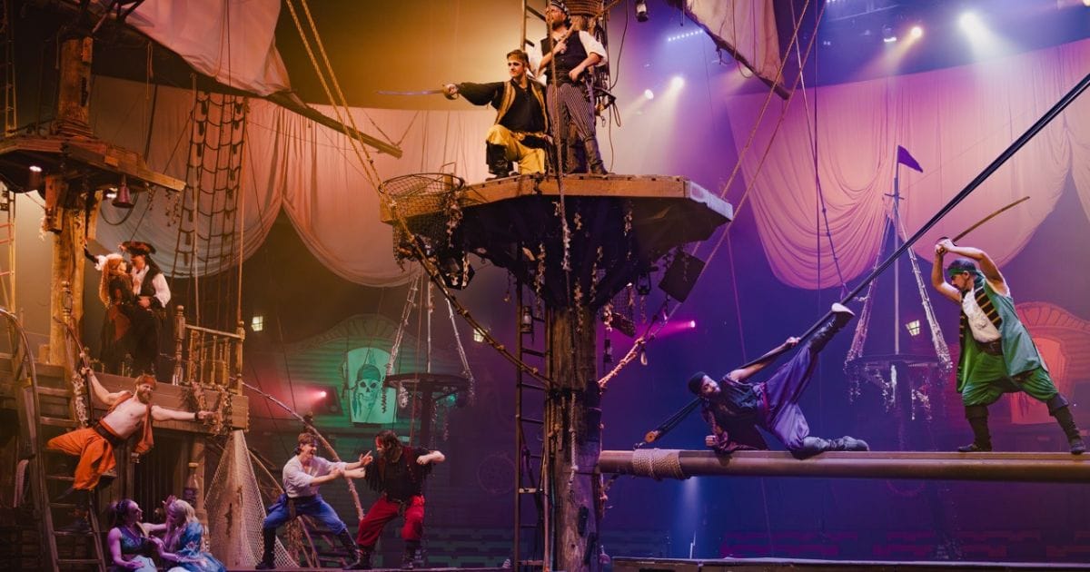 Stunt actors in pirate costumes sword fighting and balancing across ship rigging during the Vampirates dinner show in Orlando