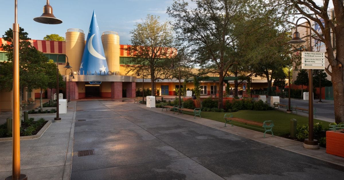 Wide-angle view down the landscaped walkway of Animation Courtyard toward the Roy E. Disney Sorcerer Hat building facade