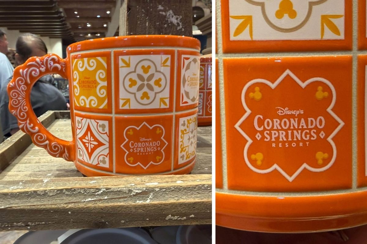 Orange ceramic mug with square mosaic patterns and an intricate scrollwork handle