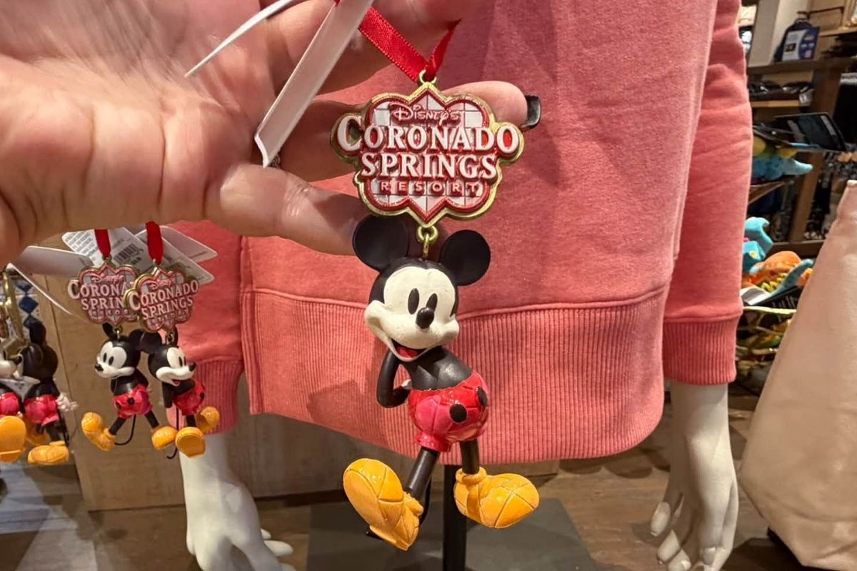 Mickey Mouse standing next to the Coronado Springs Resort logo on an ornament