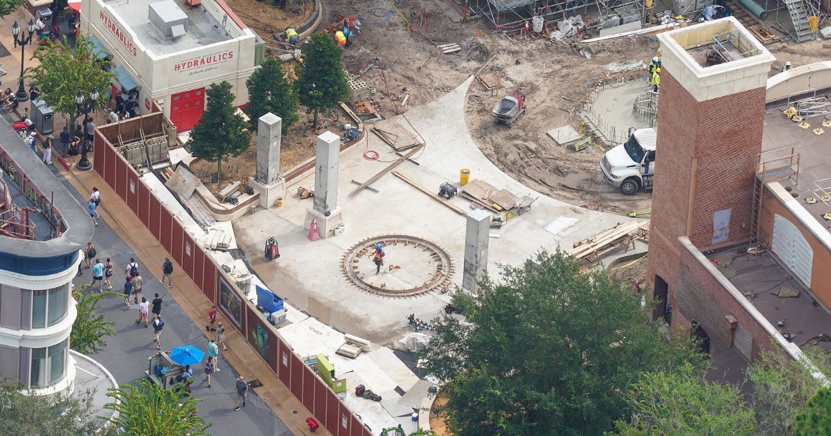 Four concrete gateway columns at the Monstropolis entrance featuring textured monster-scale panels at their bases