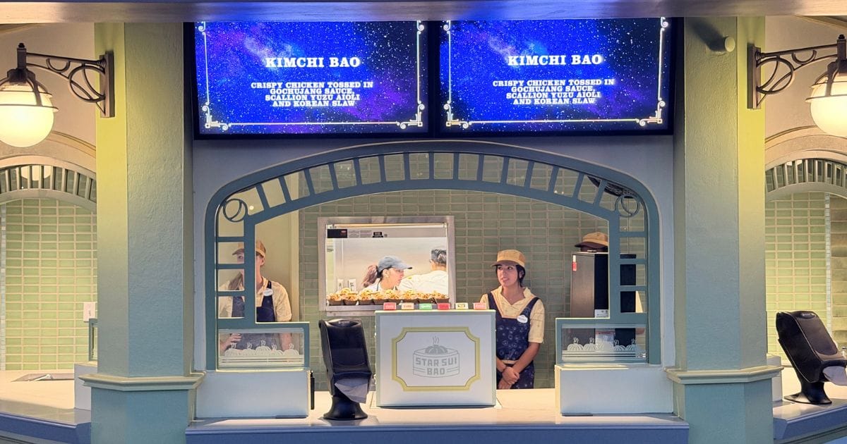 Team members ready to serve Kimchi Bao at the Star Sui Bao food kiosk in Celestial Park during an Epic Universe event.