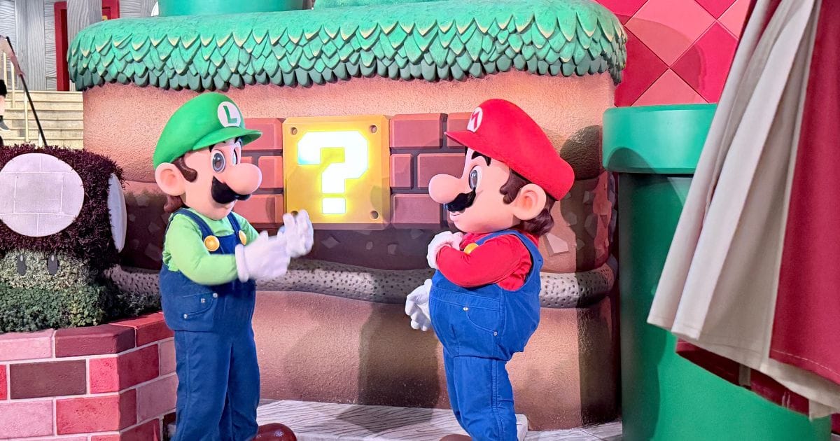 Mario and Luigi interacting with each other during a character meet and greet inside Super Nintendo World at Epic Universe.