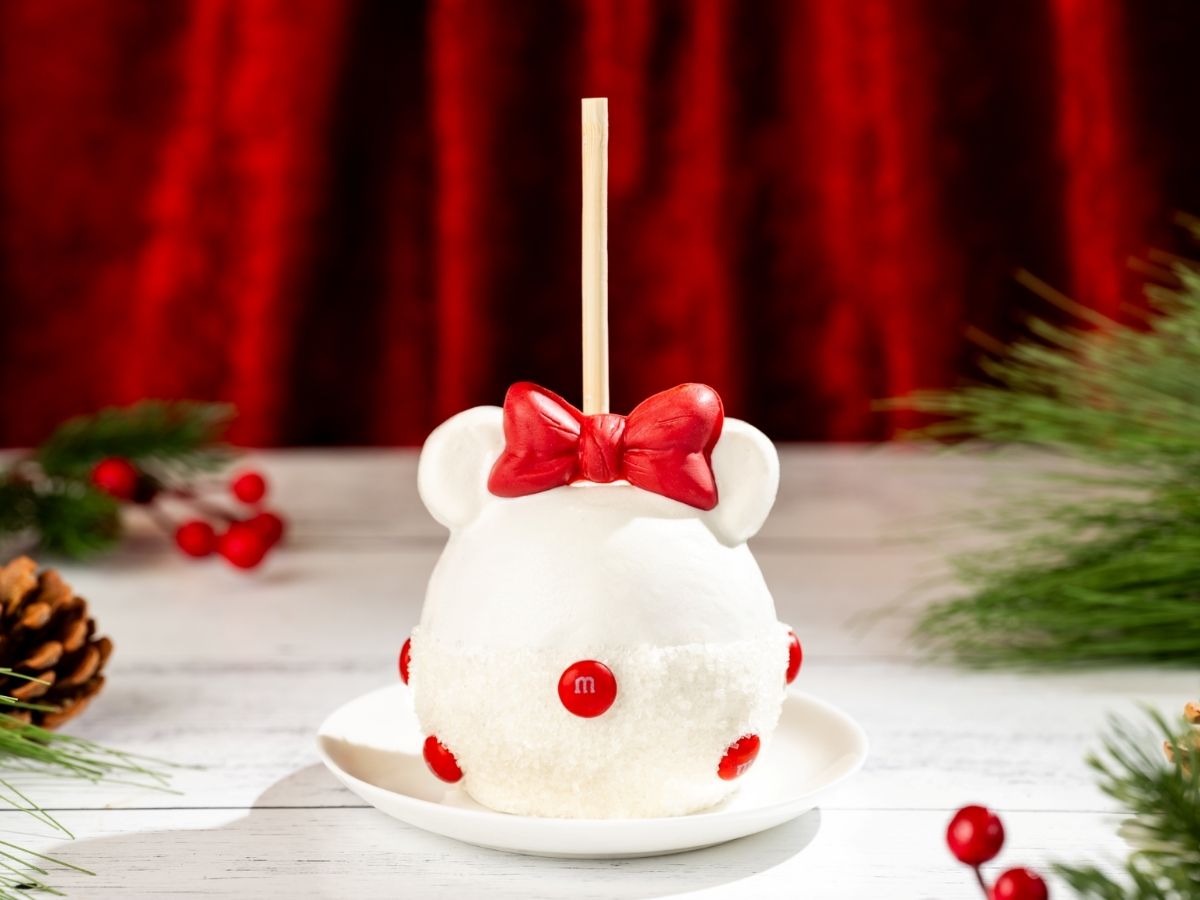 Minnie Holiday Caramel Apple with a festive bow and holiday sprinkles