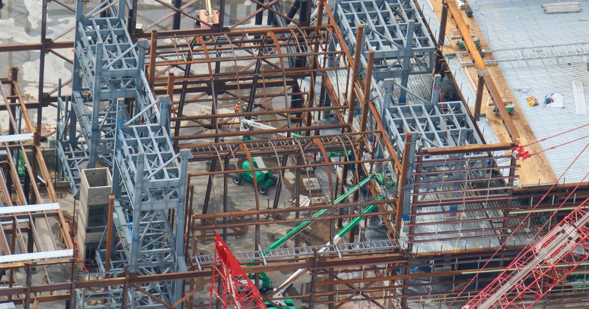 Exterior wall panels and roof decking being attached to the Monsters, Inc. Door Vault Coaster show building