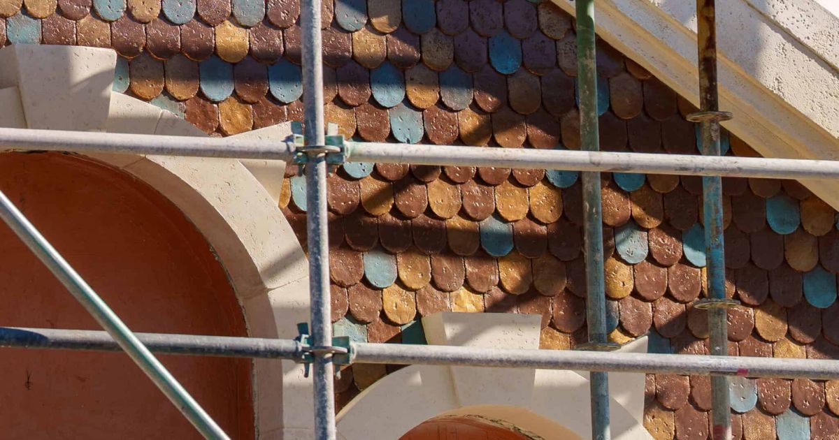 Scaffolding and painted teal, gold, and bronze gable shingles on Archie's Scare Pig Pizza along Dark Avenue in Monstropolis